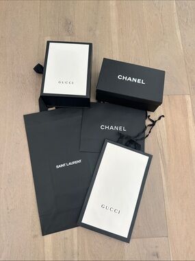 Assortment of Chanel, Saint Laurent and Gucci shopping bags and boxes